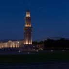 A Panorama of the Sultan Qaboos Grand Mosque in Muscat, Oman in the early evening hour showing off the dark blue sky and glowing